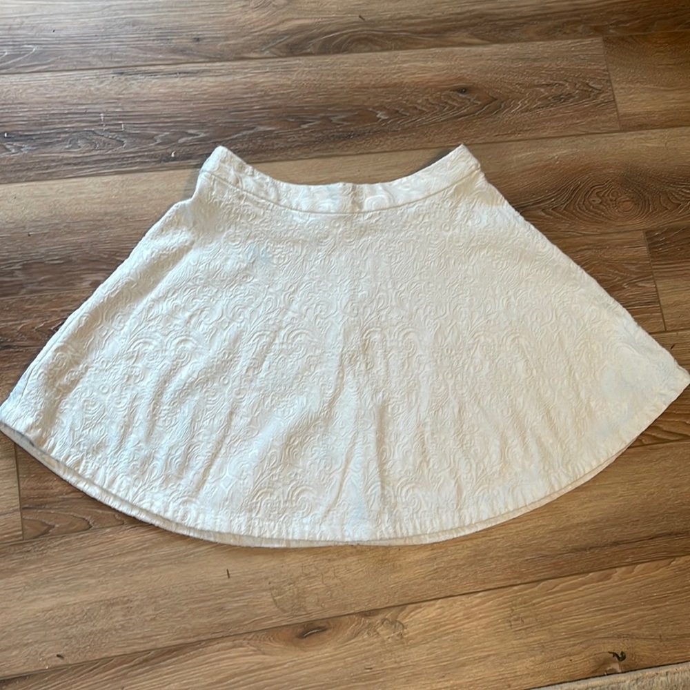 White flair skirt with textured pattern.